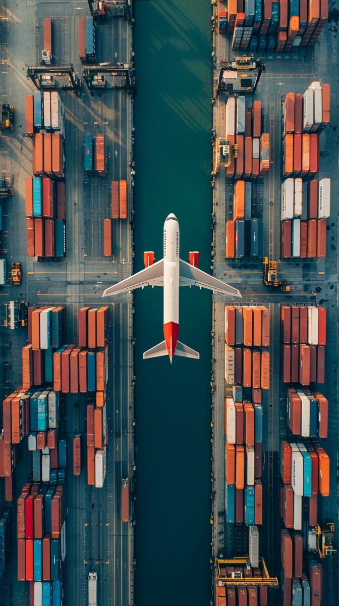 Aerial view of a logistics terminal with an aircraft centered above container stacks
